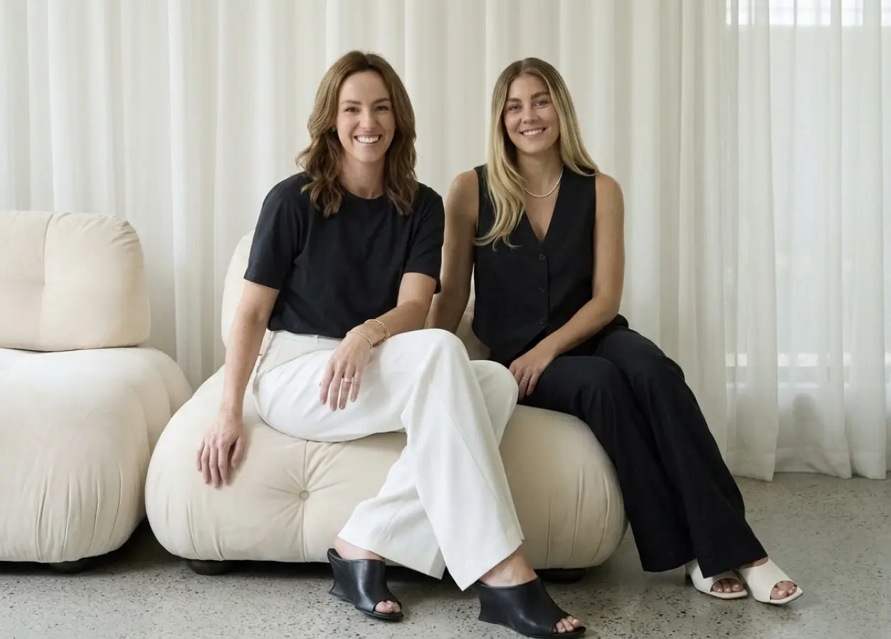 To kvinder fra Lumina sidder smilende i en lys sofa